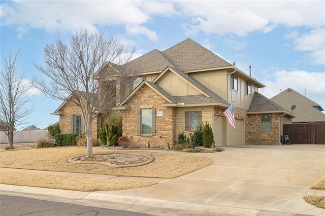 view of front of property with roof with shingles, driveway, brick siding, and fence