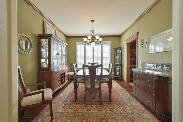 dining area with a chandelier, dark wood-style flooring, baseboards, and crown molding