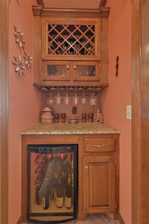 bar featuring beverage cooler, baseboards, and a dry bar