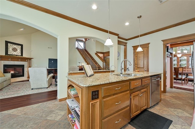 kitchen featuring arched walkways, dishwasher, a premium fireplace, light stone countertops, and a sink