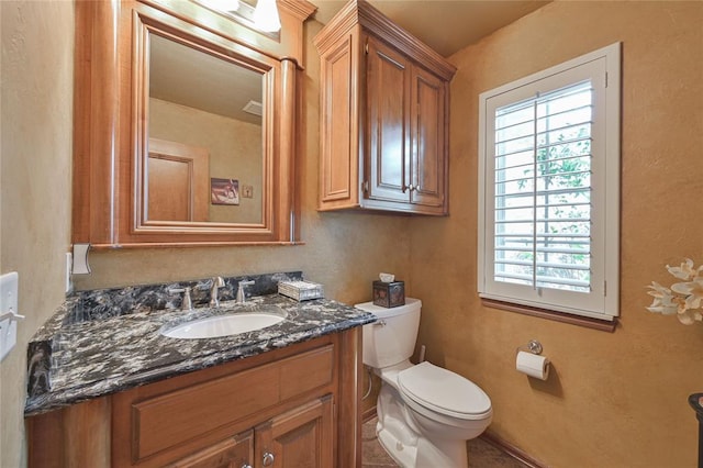 half bathroom featuring toilet and vanity