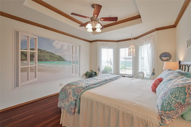 bedroom with a tray ceiling, wood finished floors, a ceiling fan, and crown molding