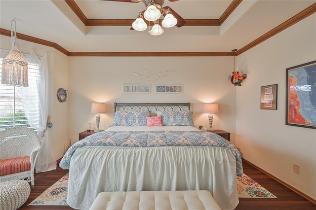 bedroom featuring ornamental molding, a ceiling fan, a raised ceiling, and wood finished floors