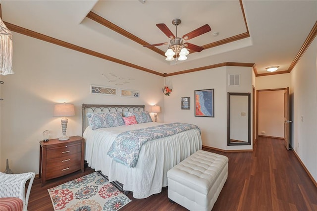 bedroom with crown molding, visible vents, a raised ceiling, and wood finished floors