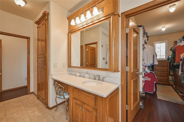 bathroom with baseboards, a closet, and vanity