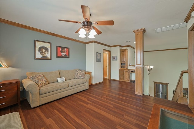 living area with ceiling fan, visible vents, ornamental molding, dark wood finished floors, and ornate columns