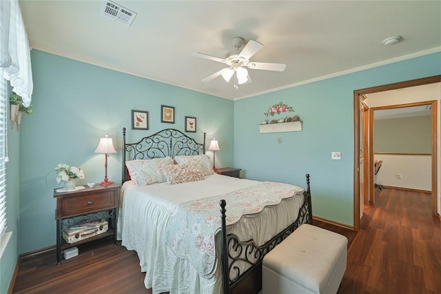 bedroom featuring ceiling fan, wood finished floors, visible vents, baseboards, and crown molding