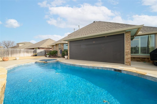 view of swimming pool featuring a patio, fence, and a pool with connected hot tub