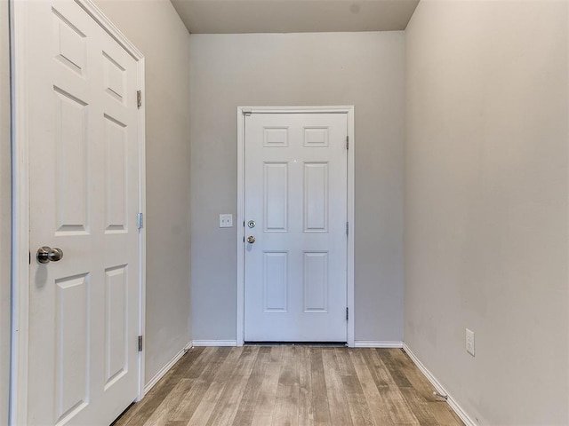 doorway with baseboards and wood finished floors