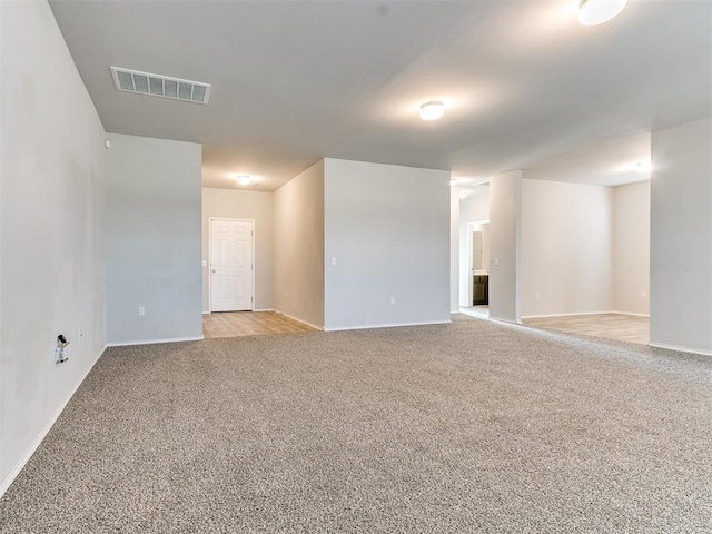 basement featuring light colored carpet and visible vents