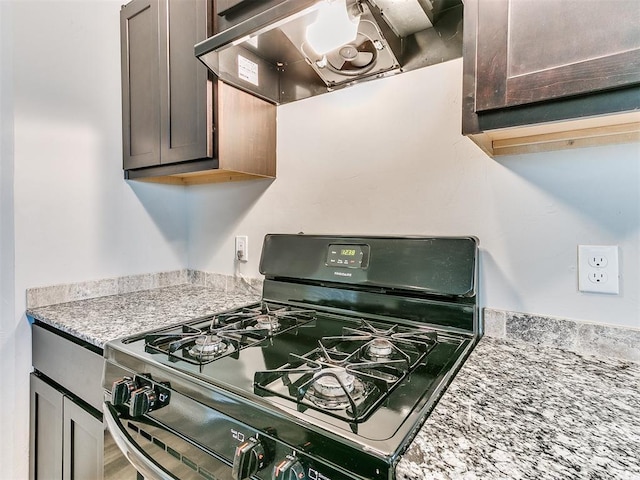 kitchen featuring dark brown cabinetry, gas range, and range hood