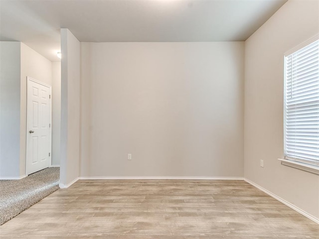 unfurnished room featuring baseboards and light wood-style floors