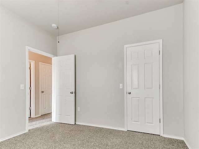 unfurnished bedroom with light carpet and baseboards