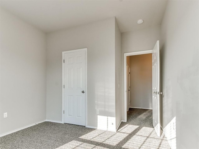 unfurnished bedroom featuring carpet and baseboards