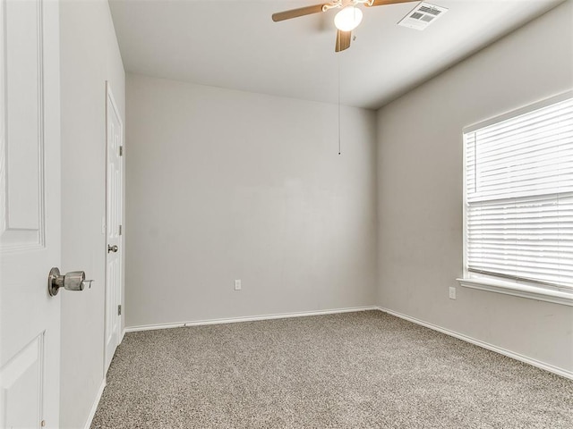 carpeted spare room with baseboards, visible vents, and a ceiling fan