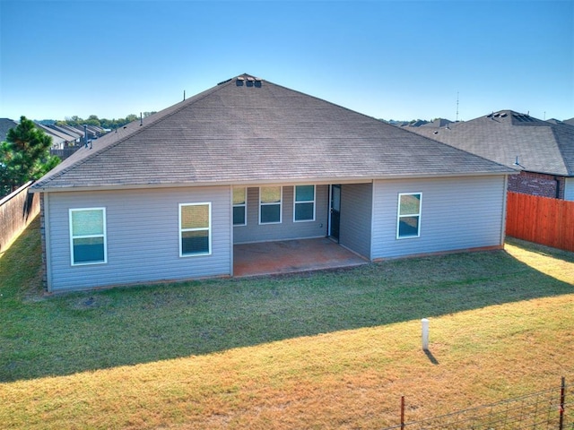 back of property featuring a yard, roof with shingles, a patio area, and a fenced backyard