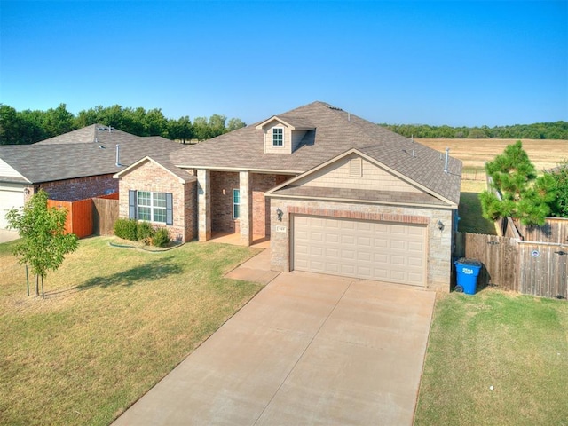 view of front of home with brick siding, fence, a garage, driveway, and a front lawn