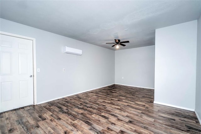 empty room with ceiling fan, a wall unit AC, wood finished floors, and baseboards