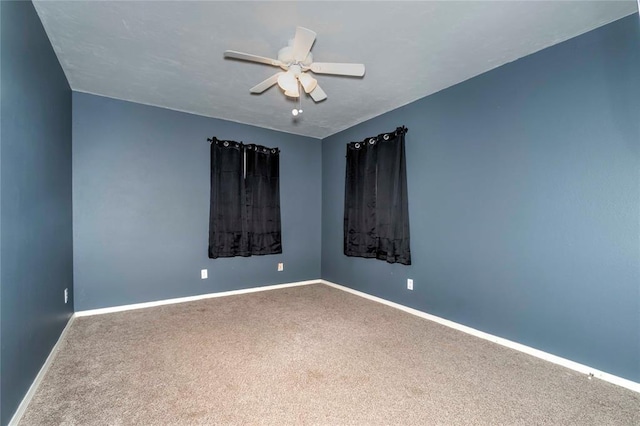 empty room with carpet flooring, a ceiling fan, and baseboards