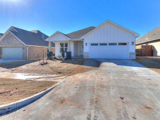 ranch-style home with a garage, concrete driveway, brick siding, and board and batten siding