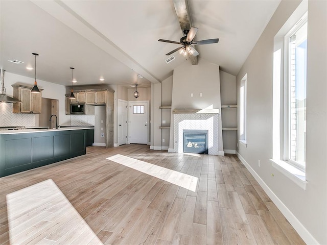 unfurnished living room featuring light wood-type flooring, baseboards, lofted ceiling with beams, and visible vents