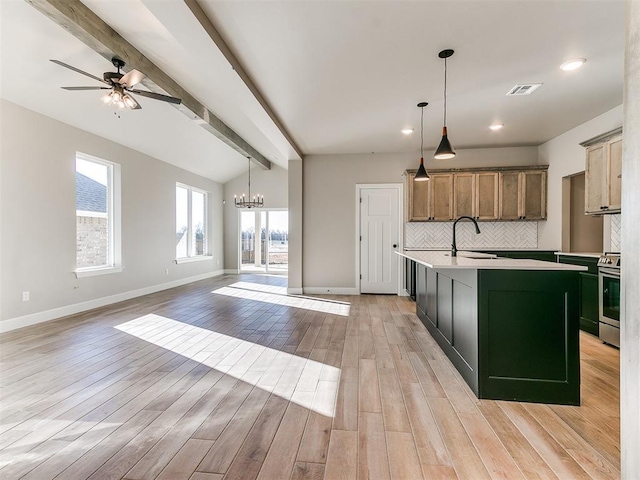 kitchen with open floor plan, stainless steel electric range, backsplash, and a kitchen island with sink