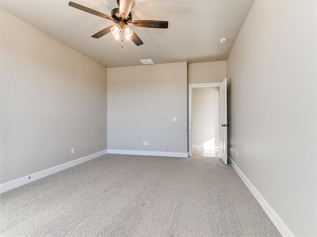 empty room with ceiling fan, visible vents, baseboards, and light colored carpet