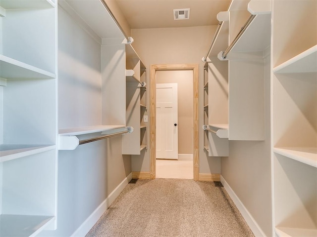 walk in closet with visible vents and light carpet