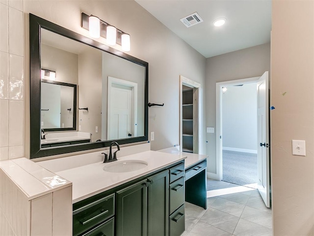 bathroom with tile patterned flooring, vanity, visible vents, and baseboards