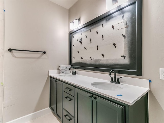 bathroom with tile patterned flooring, a sink, baseboards, and double vanity