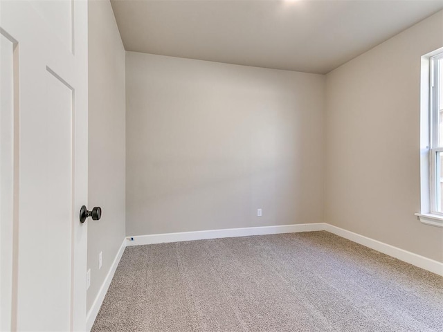 carpeted spare room with baseboards