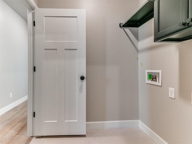 laundry room featuring hookup for a washing machine, cabinet space, and baseboards