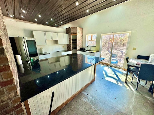 kitchen featuring concrete floors, dark countertops, wood ceiling, and white cabinets