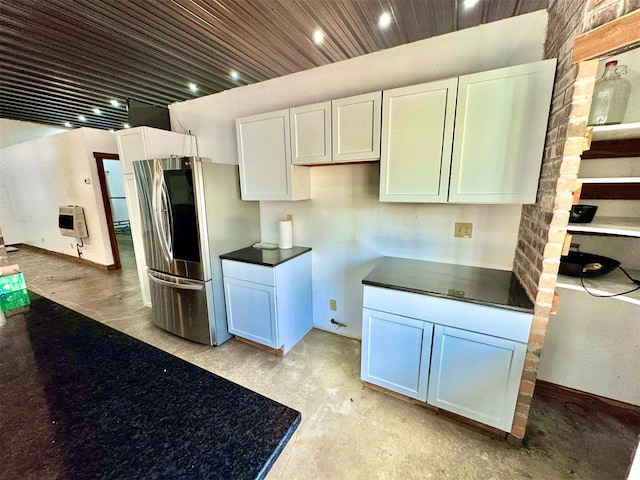 kitchen featuring heating unit, dark countertops, smart refrigerator, and white cabinetry