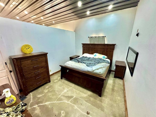 bedroom with wood ceiling, baseboards, and concrete flooring