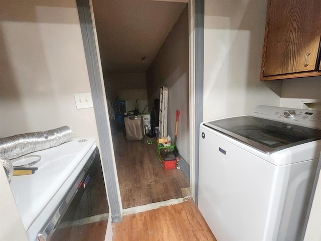 laundry area featuring cabinet space, washer and clothes dryer, and light wood-style floors