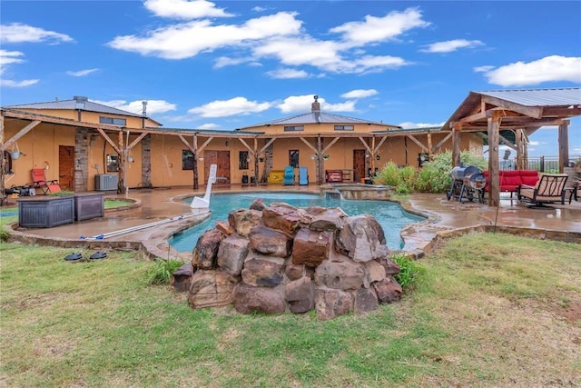 view of swimming pool featuring a pool with connected hot tub, a patio, and central AC unit