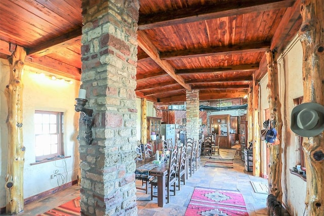 unfurnished dining area with wood ceiling, stone tile flooring, and decorative columns