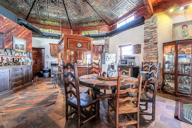 dining area featuring an ornate ceiling, stone tile floors, and a high ceiling