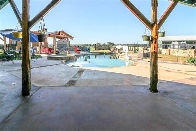 view of pool featuring a pool with connected hot tub, a patio, a gazebo, and fence