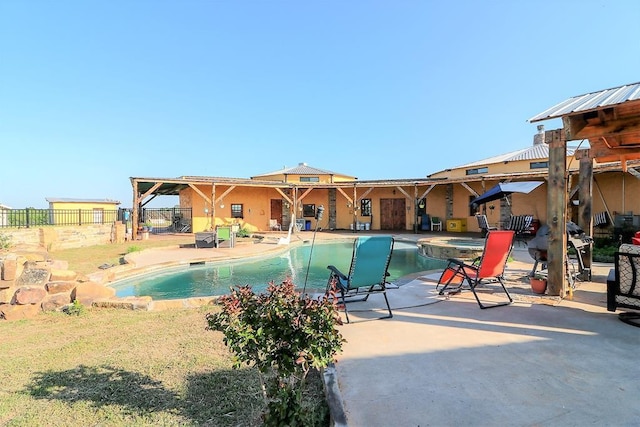 view of pool featuring a pool with connected hot tub, a patio, and fence