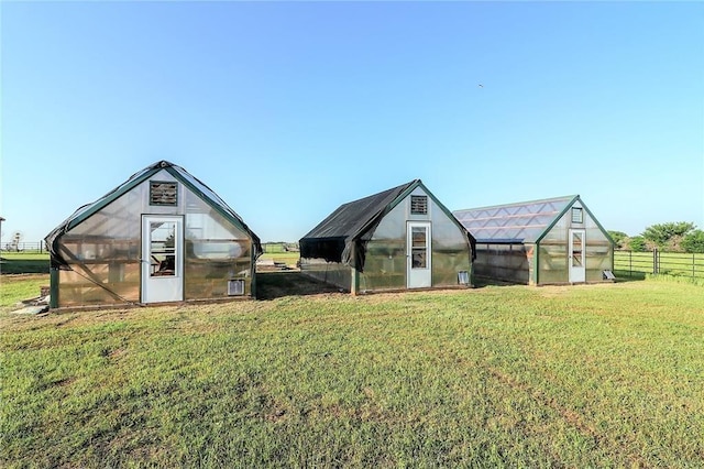 view of yard featuring fence, an outdoor structure, and an exterior structure