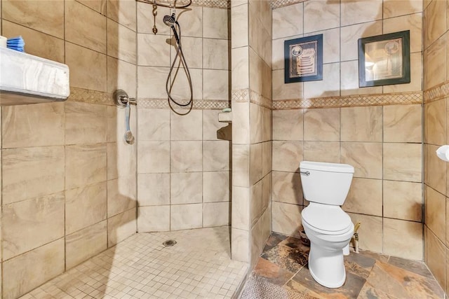 full bathroom with stone finish floor, tiled shower, and toilet