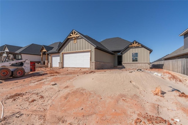 view of front facade with fence, brick siding, a garage, dirt driveway, and board and batten siding