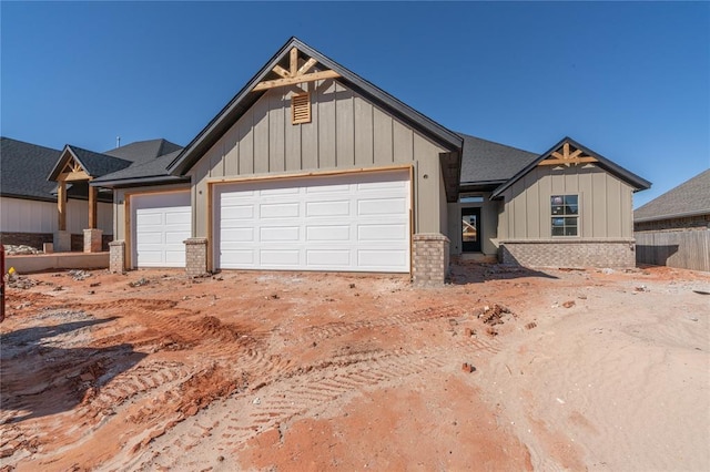 view of front of property featuring a garage, brick siding, board and batten siding, and roof with shingles