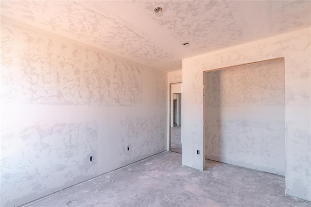 unfurnished bedroom with unfinished concrete flooring