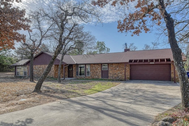 ranch-style home with driveway, a shingled roof, a chimney, a garage, and stone siding