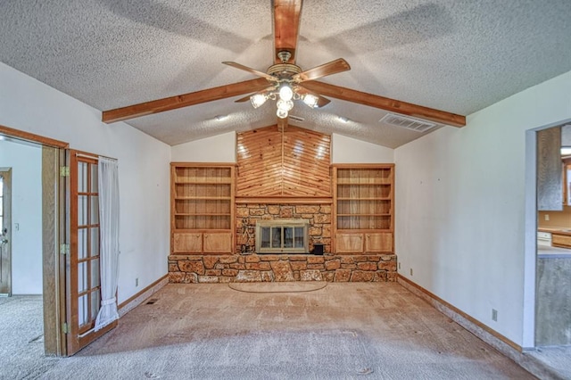 unfurnished living room with visible vents, lofted ceiling with beams, carpet floors, a fireplace, and a textured ceiling