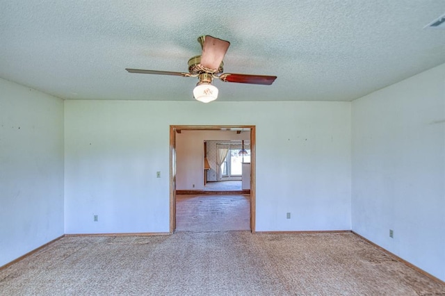 carpeted spare room with baseboards, a textured ceiling, and a ceiling fan