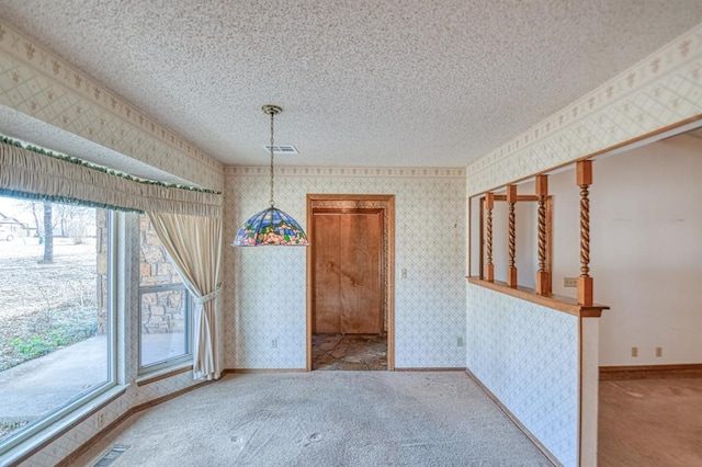 carpeted empty room with wallpapered walls, visible vents, baseboards, and a textured ceiling